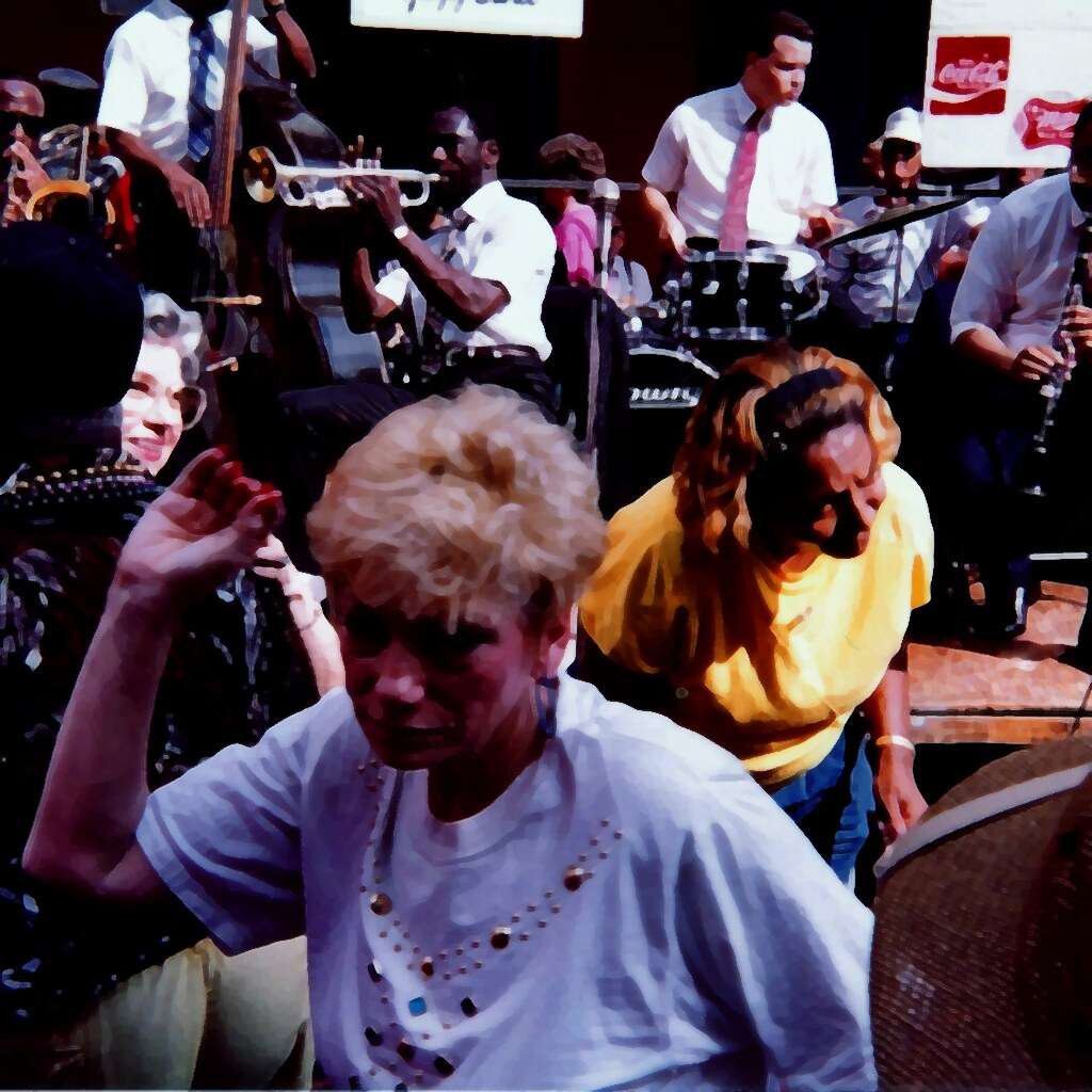 People dancing in front of a brass band at the French Quarter Festival in New Orleans